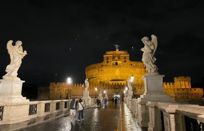 Castel Sant Angelo illuminated at night on the banks of the Tiber during a Rome ghost tour